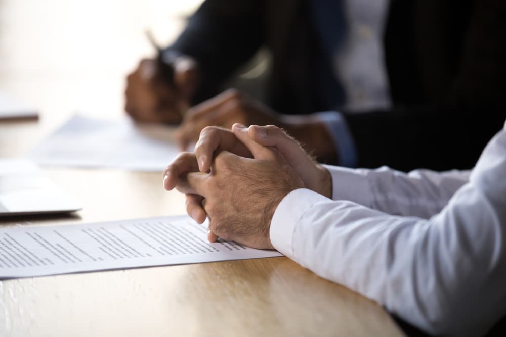 Lawyer consulting client about a legal document, discussing financial and legal services during a contract signing.