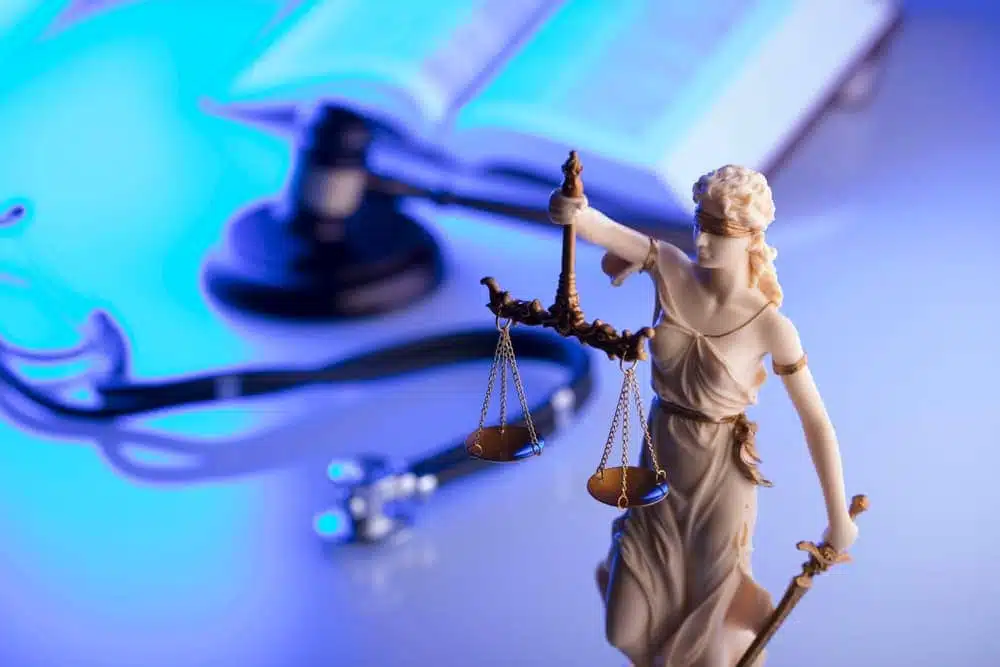 Legal and medical elements - gavel, stethoscope, and blue light. Space for text.