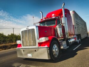 Large American truck on the road, transporting cargo. Peterbilt heavy vehicle with trailer in motion.