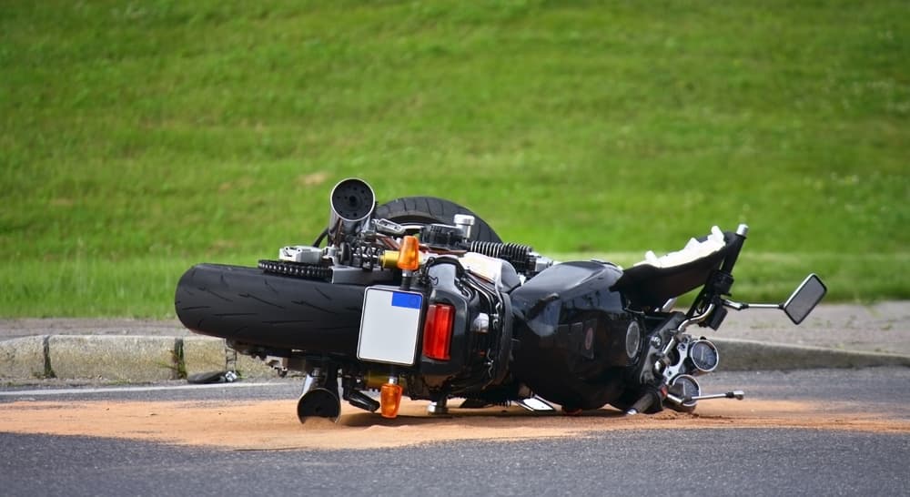 Escena callejera tras un accidente de moto con la moto dañada y alrededores.