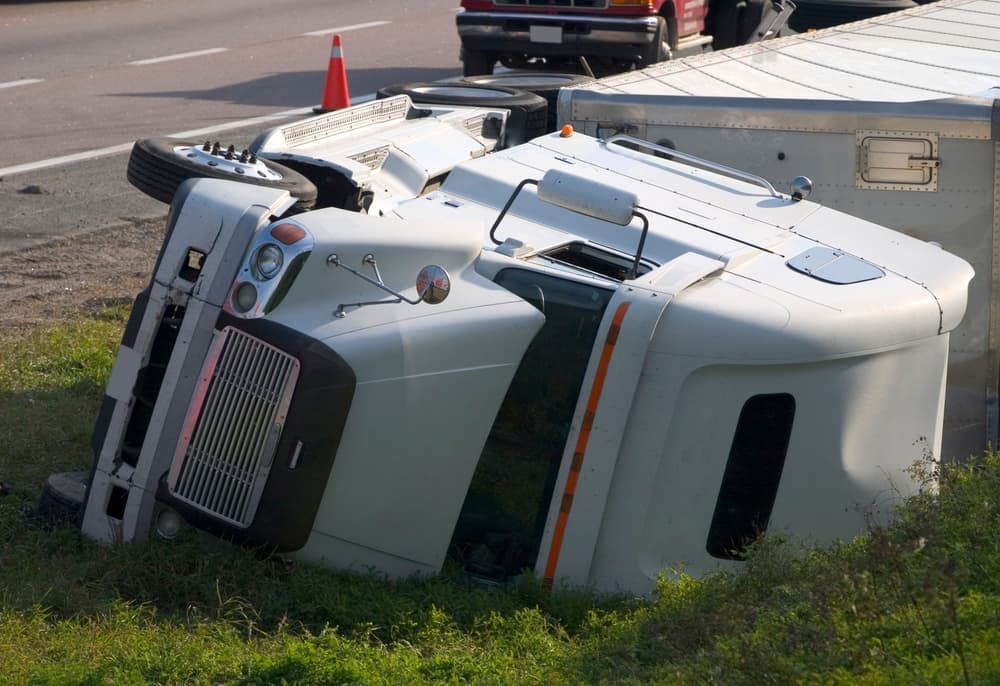 Camión volcado al borde de la carretera, secuelas de un accidente.