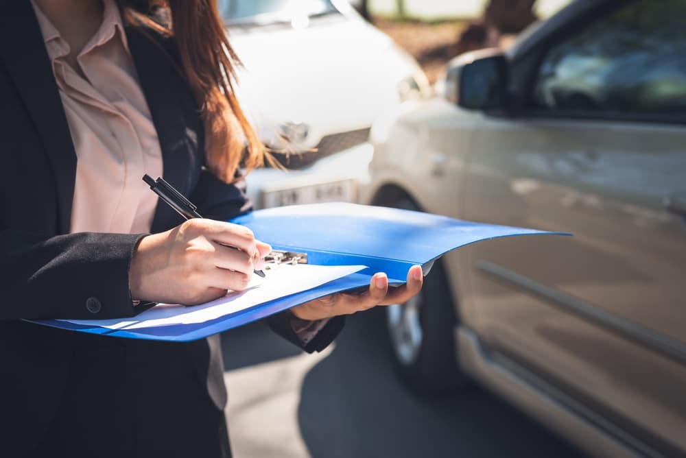 Woman reporting a car accident to insurance agents, highlighting people and transportation insurance concepts.