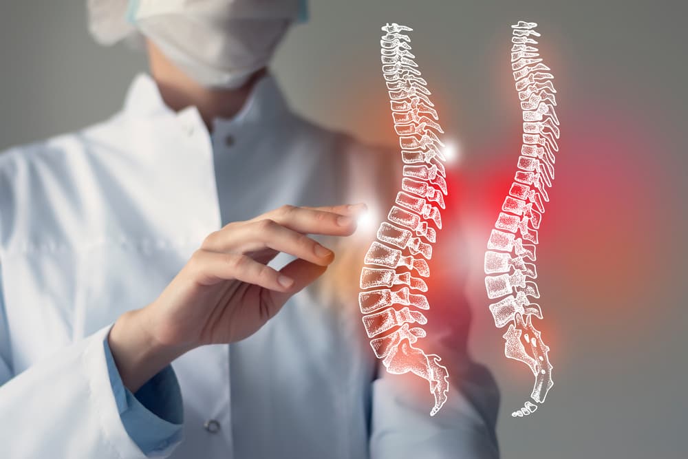 Female doctor examines virtual spine model, highlighting areas of concern in red. Healthcare and hospital service concept.