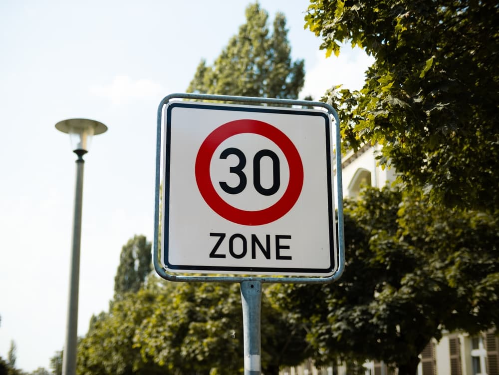 The traffic sign is located in a residential district to slow down the car drivers for safety reasons.